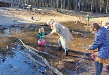 Vrouw met kind in een diepe plas met water