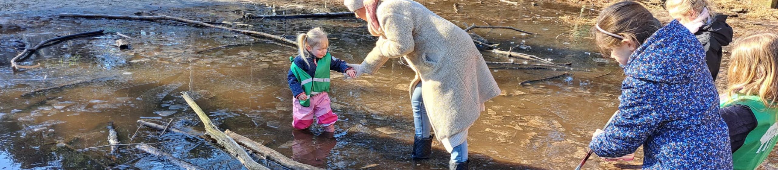 Vrouw met kind in een diepe plas met water