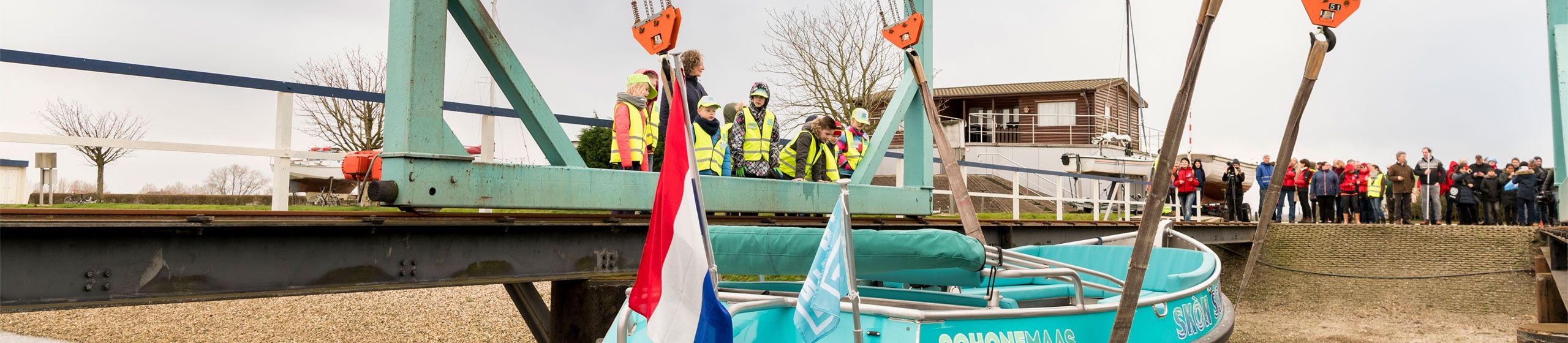 MikMakkers kijken toe hoe de boot ter water gaat.
