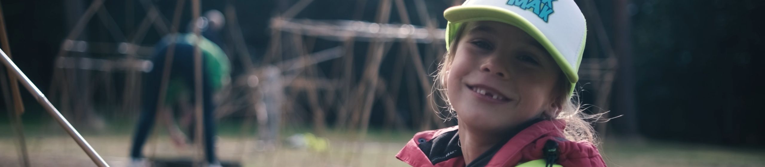 Een MikMakker is lachend aan het bouwen met bamboe
